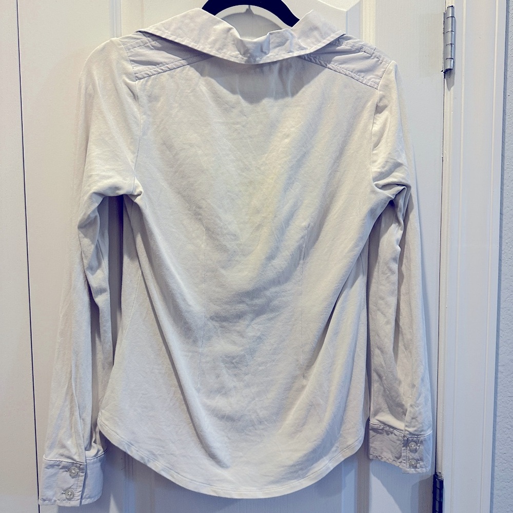 White top with long sleeves. Unique design by Cabi, zips up.